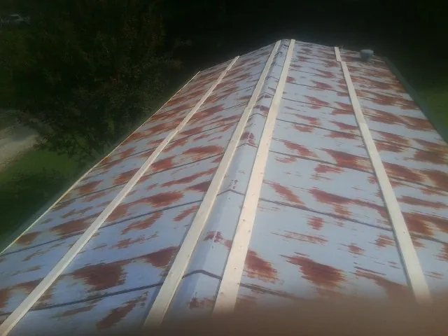Rusted metal roof panels with new wood purlins before replacement — Storm Damage Roof Repair in Erving by Roofing Brothers
